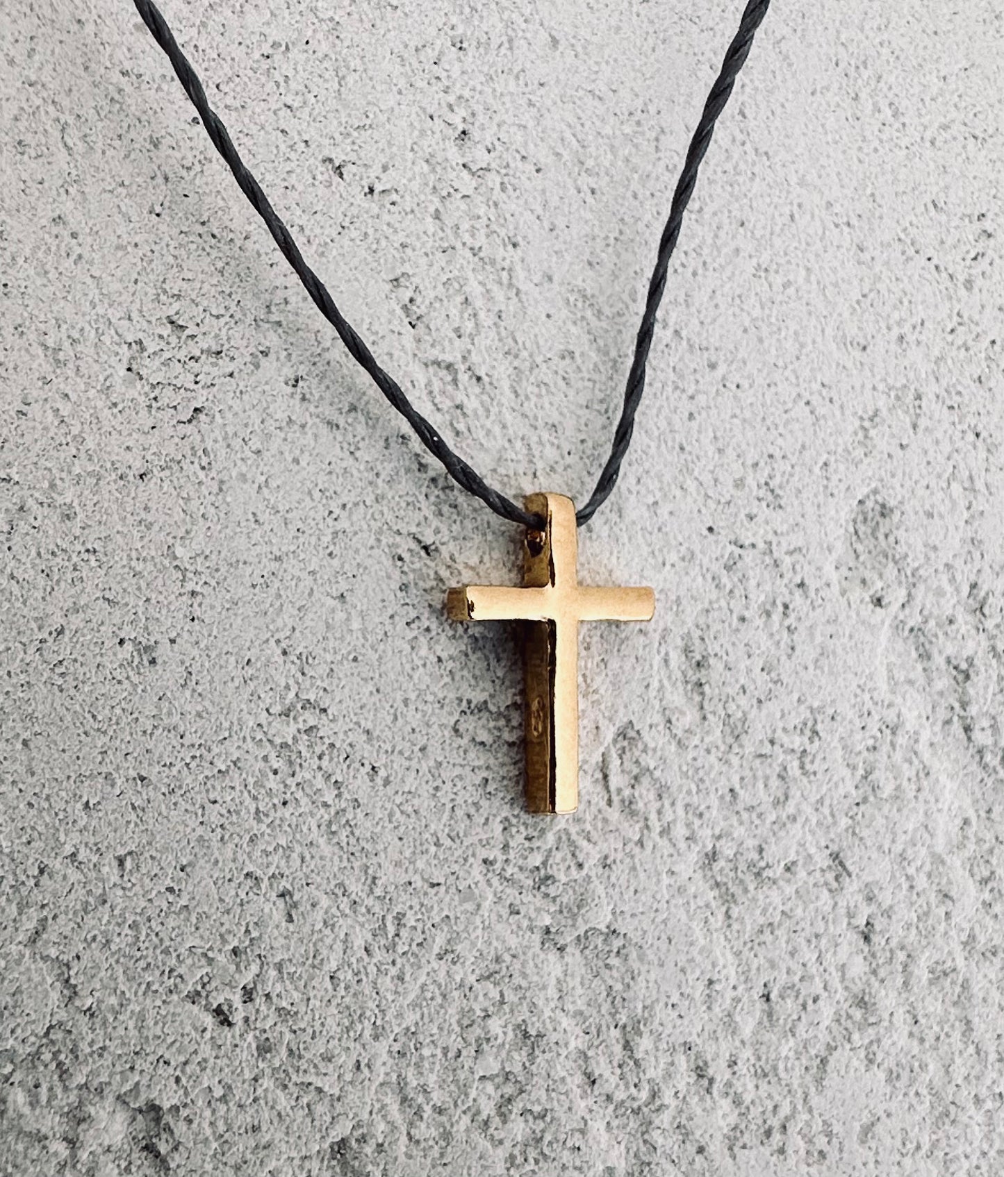 Simple gold cross on the cord.