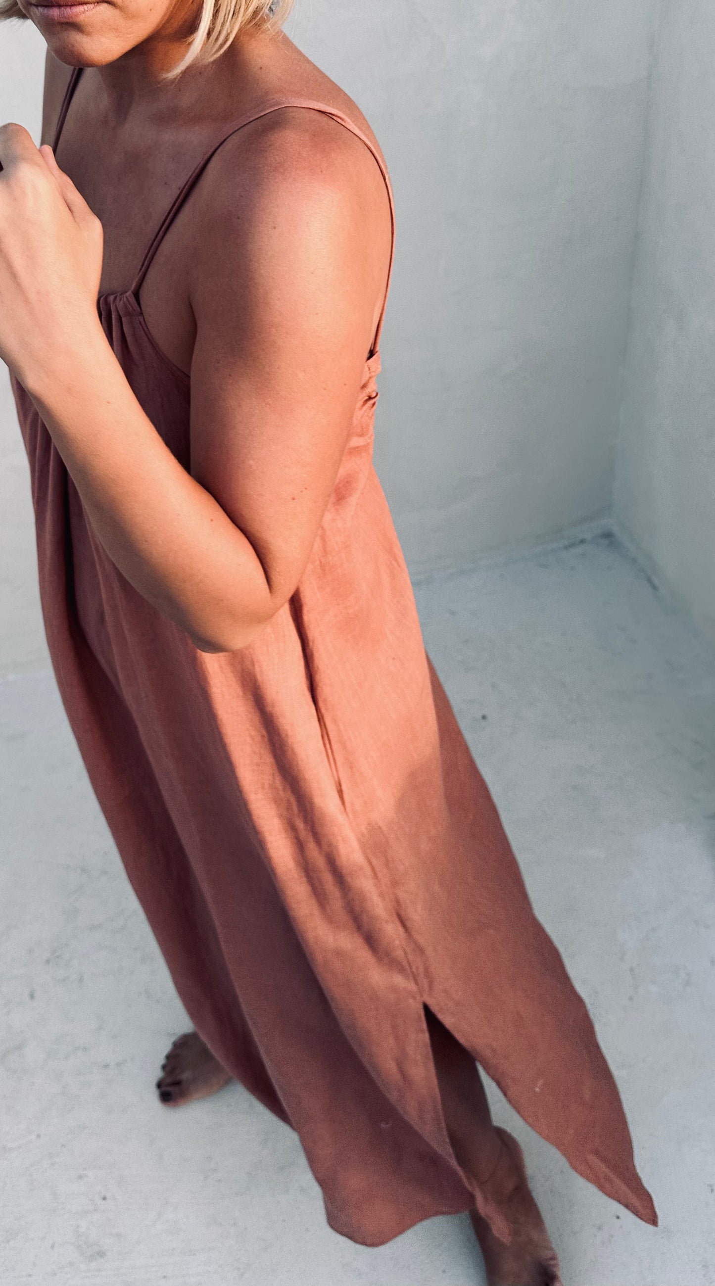 A woman wearing a cinnamon linen dress.