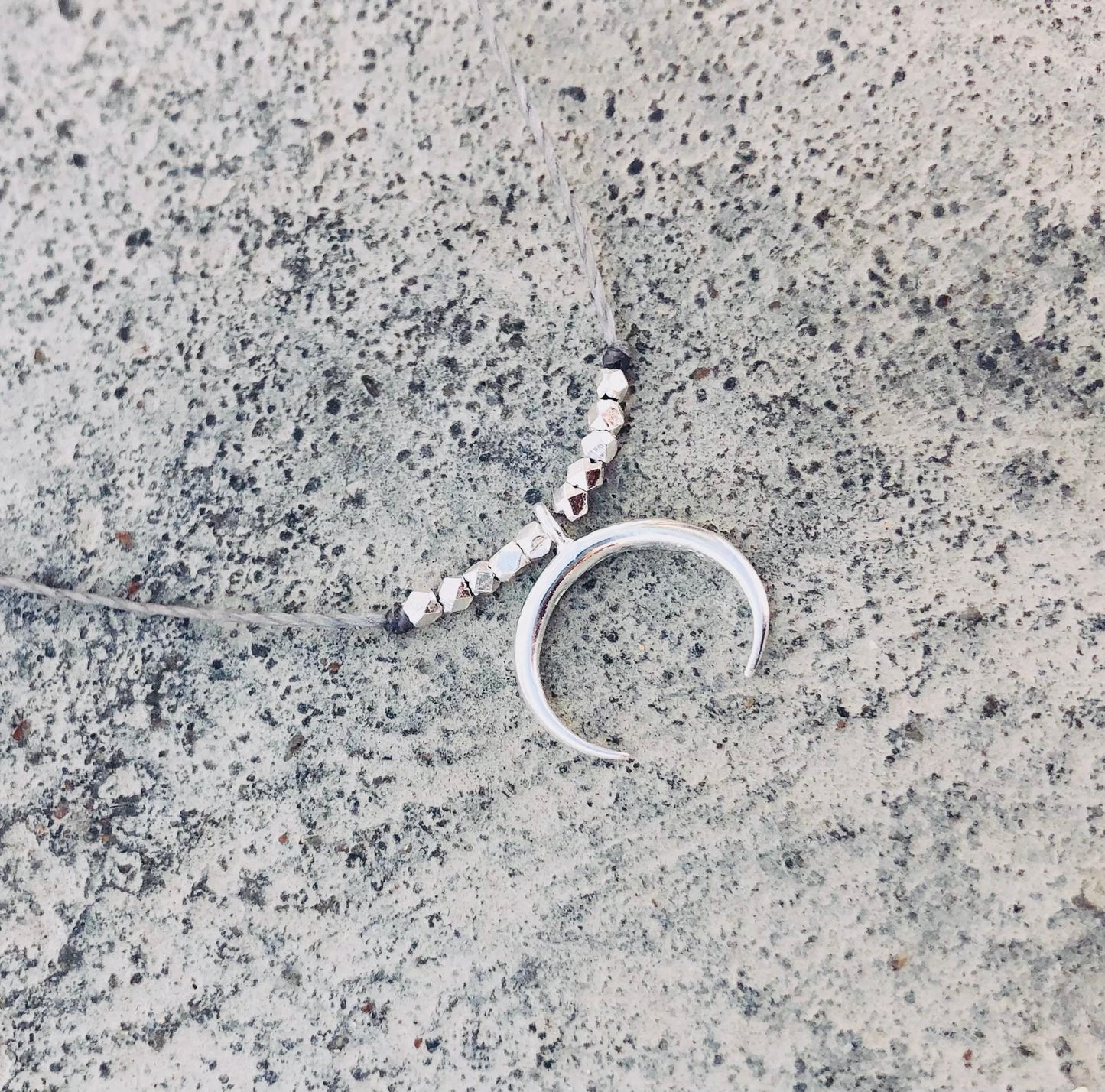 Silver moon necklace with concrete backround