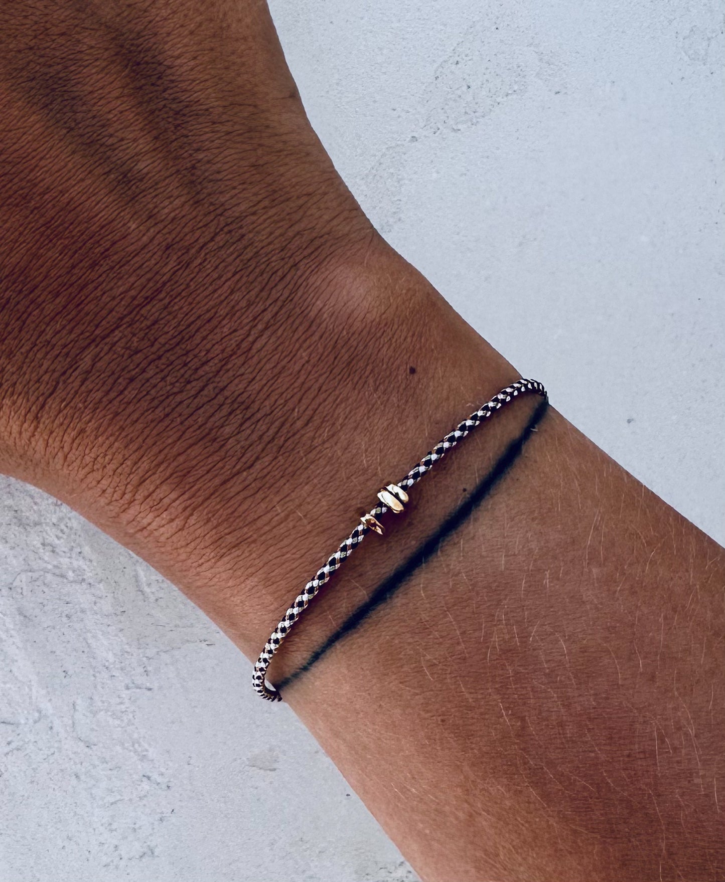 Women’s hand with a delicate braid cord bracelet