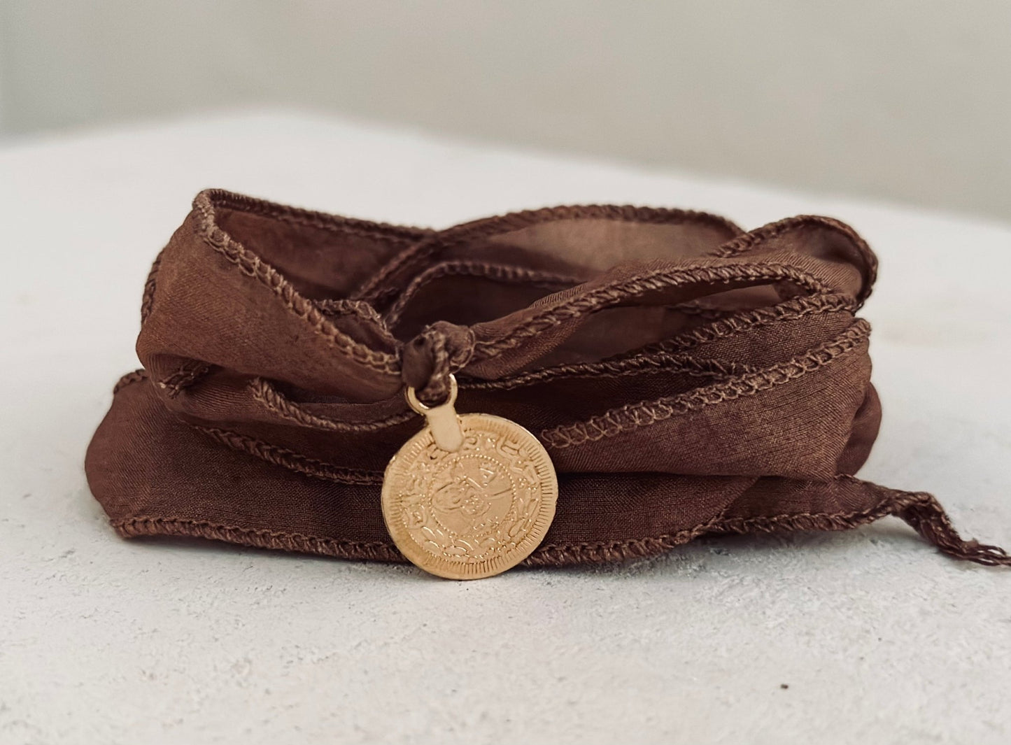 Handmade silk bracelet with a pendant on it
