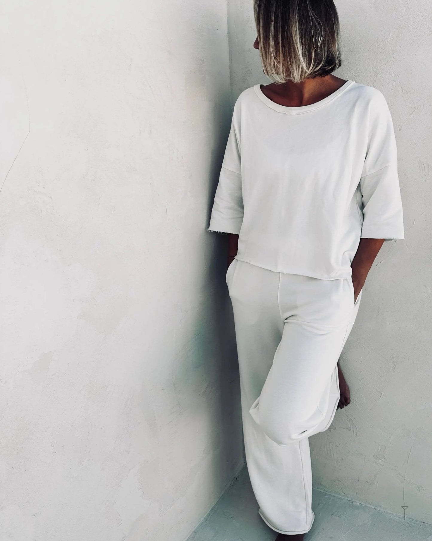 A woman wearing white pants and a white top