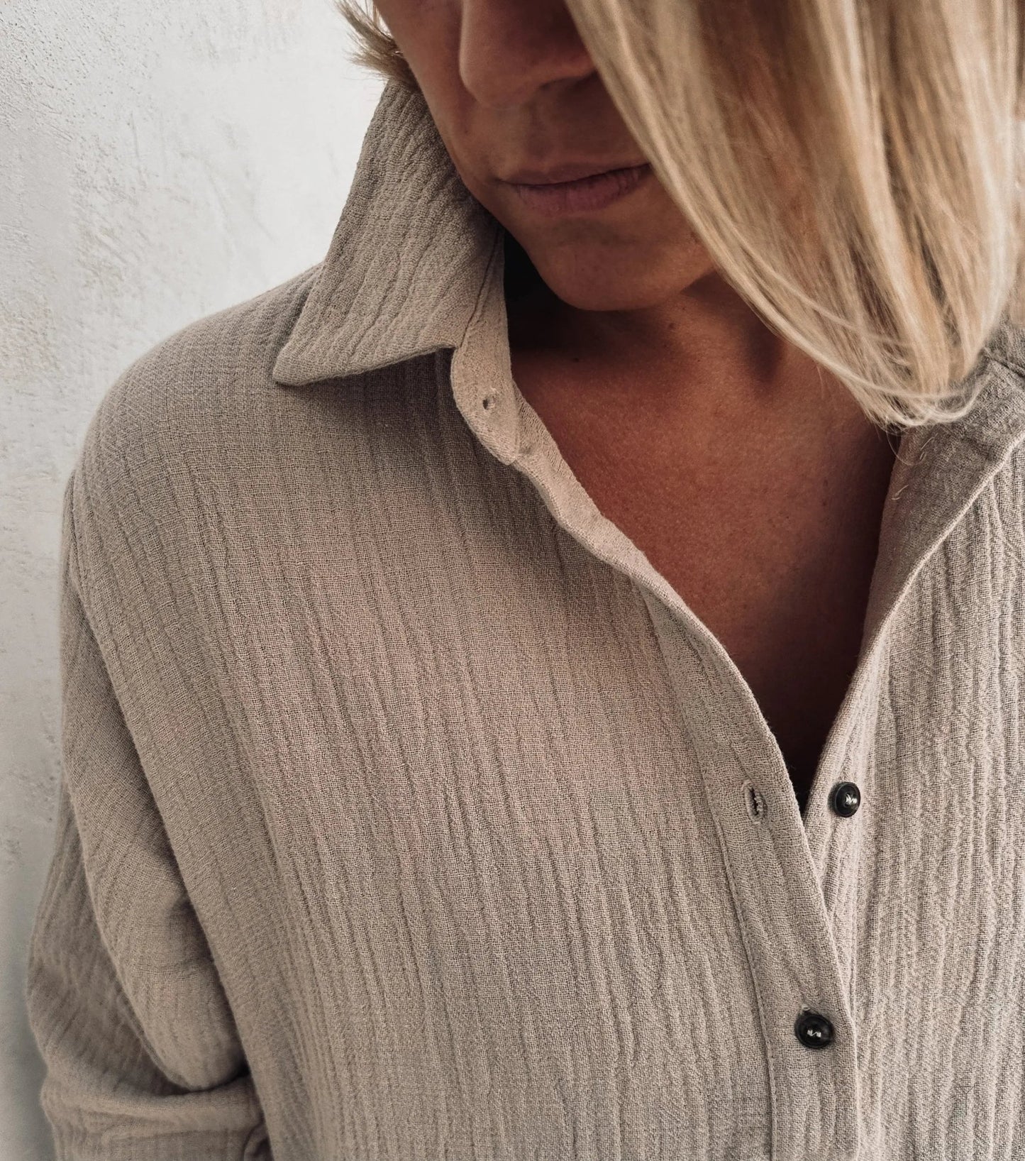 A woman wearing a beige shirt dress.