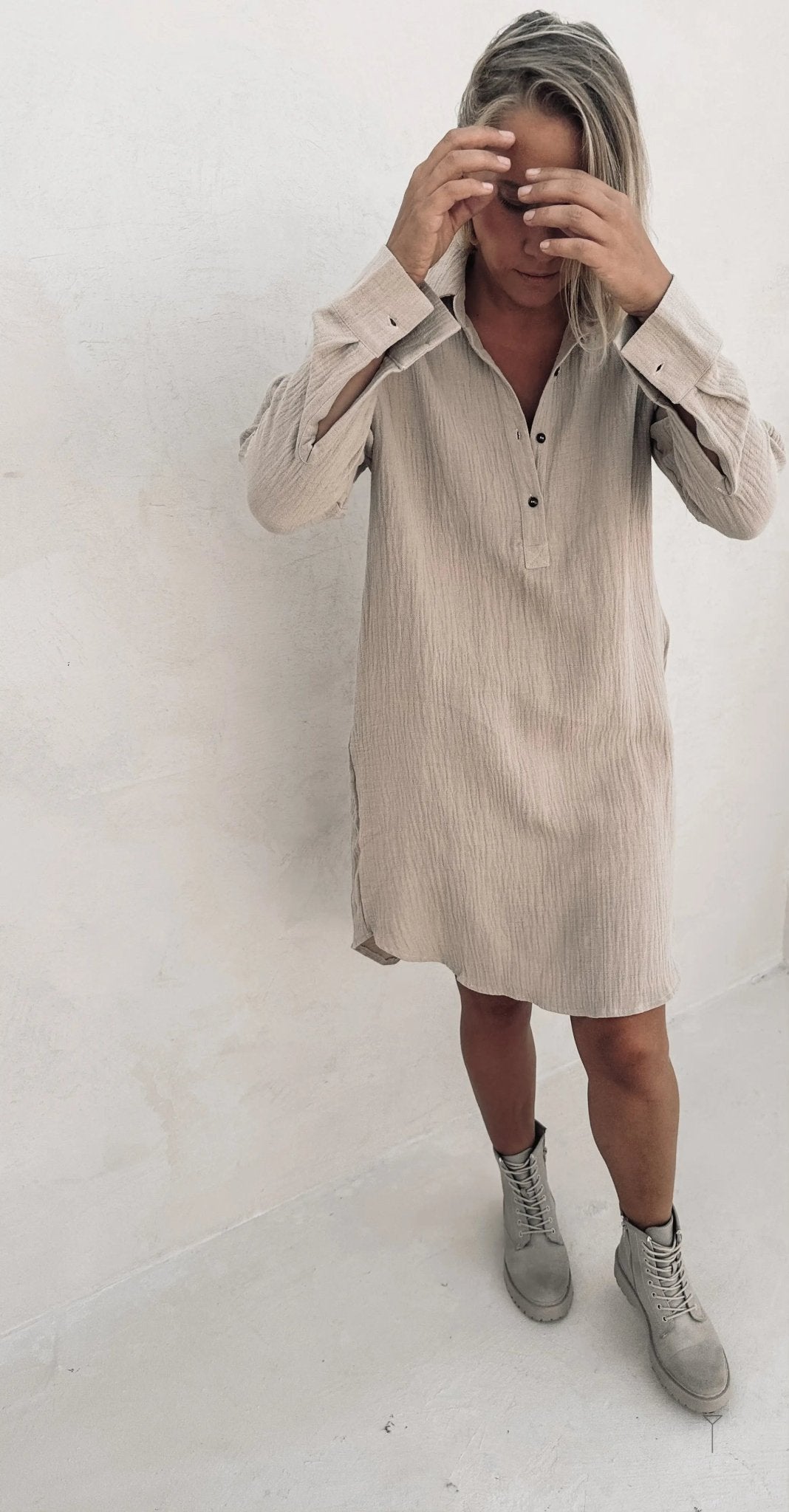 A woman wearing a beige shirt dress.