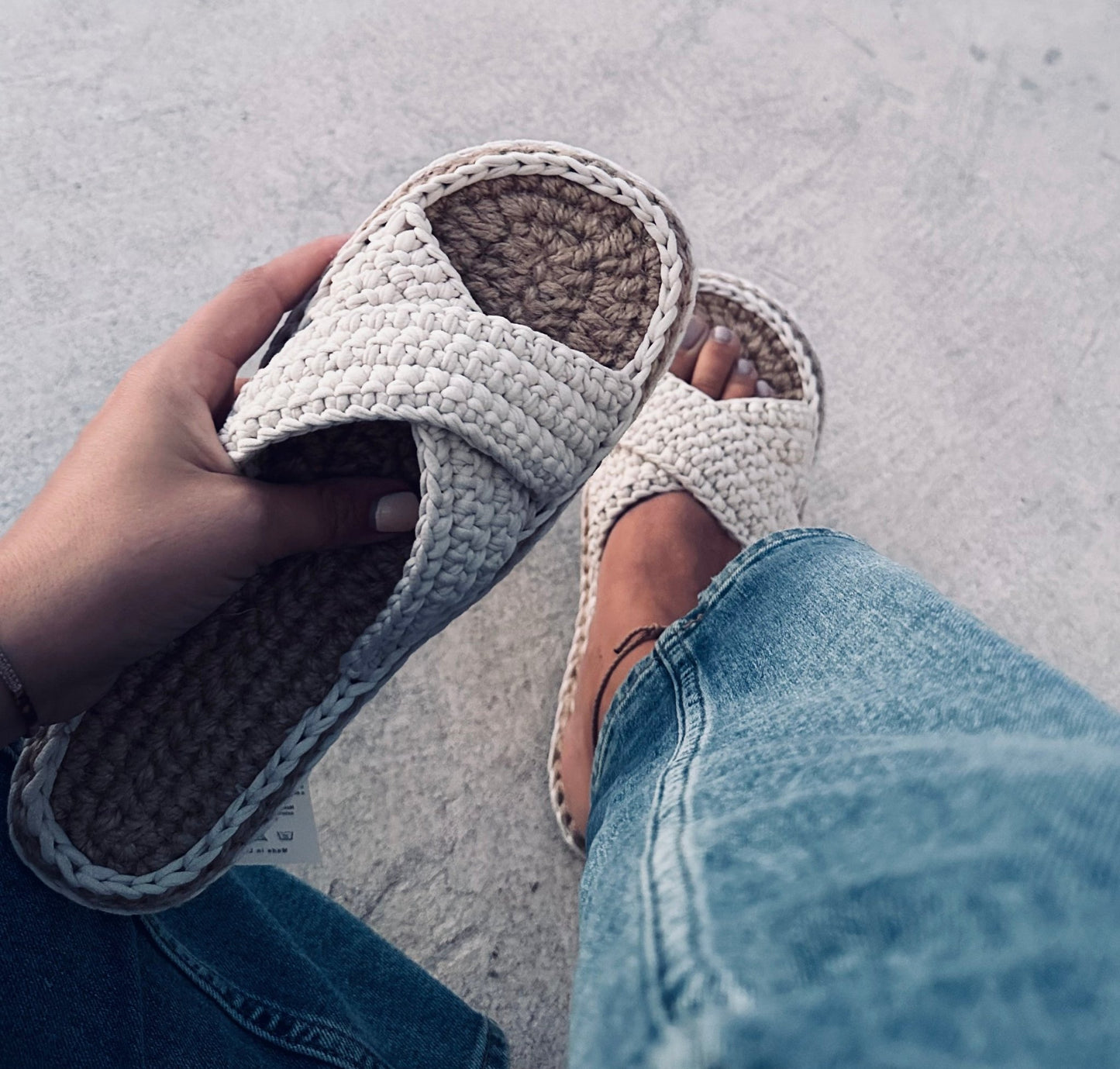 Hand holding crochet slippers 