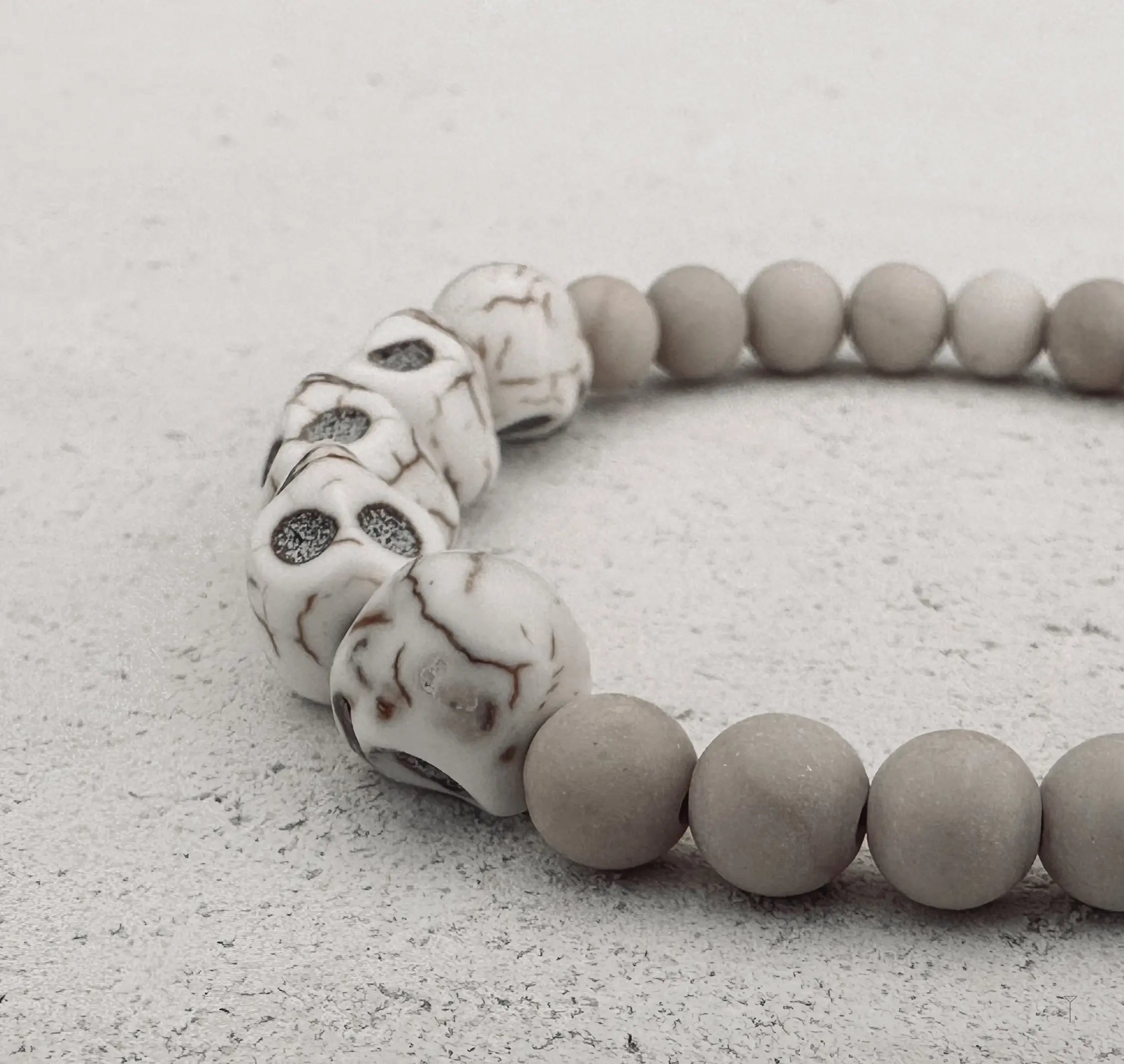 A white and ivory bracelet with a skulls on it. 