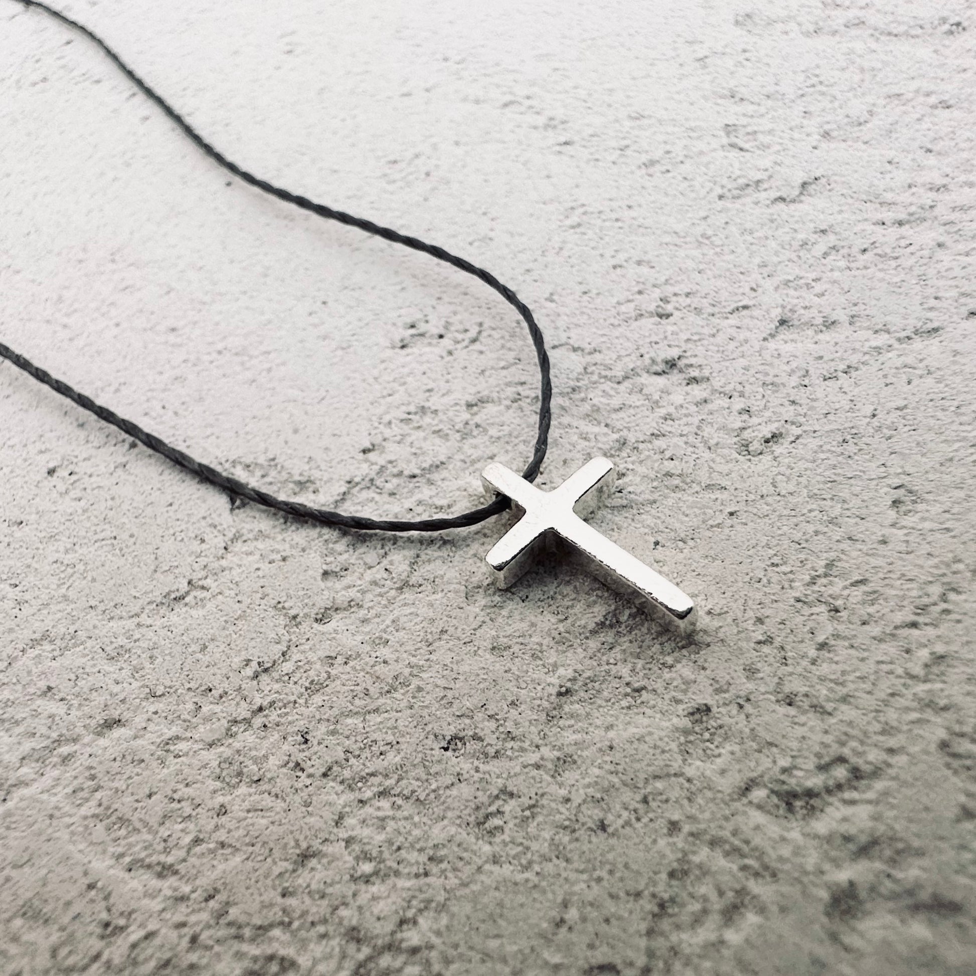 Minimal silver cross and cord necklace. 