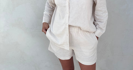 A woman wearing ivory linen viscose shorts. 