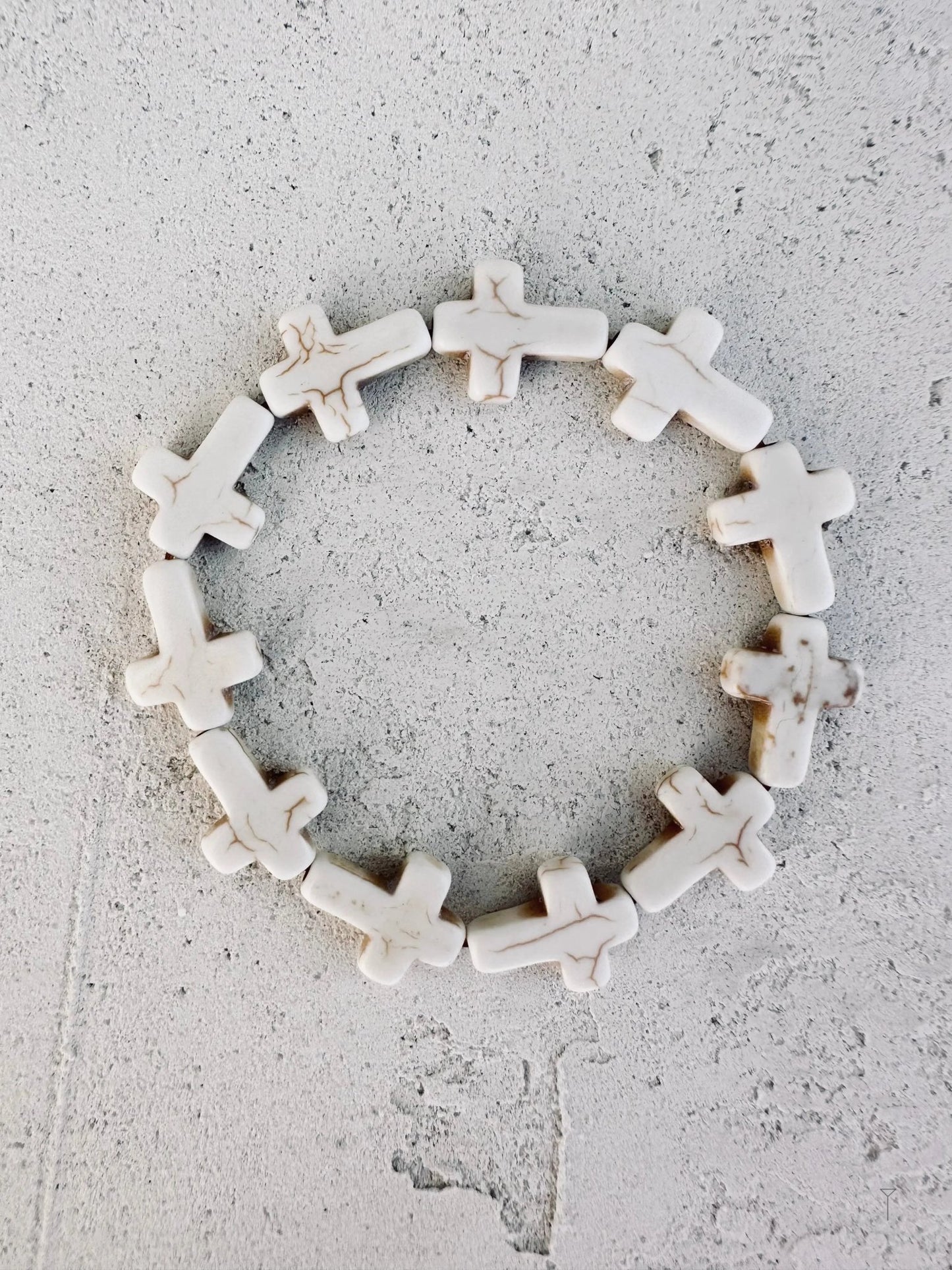 A white cross bracelet. 