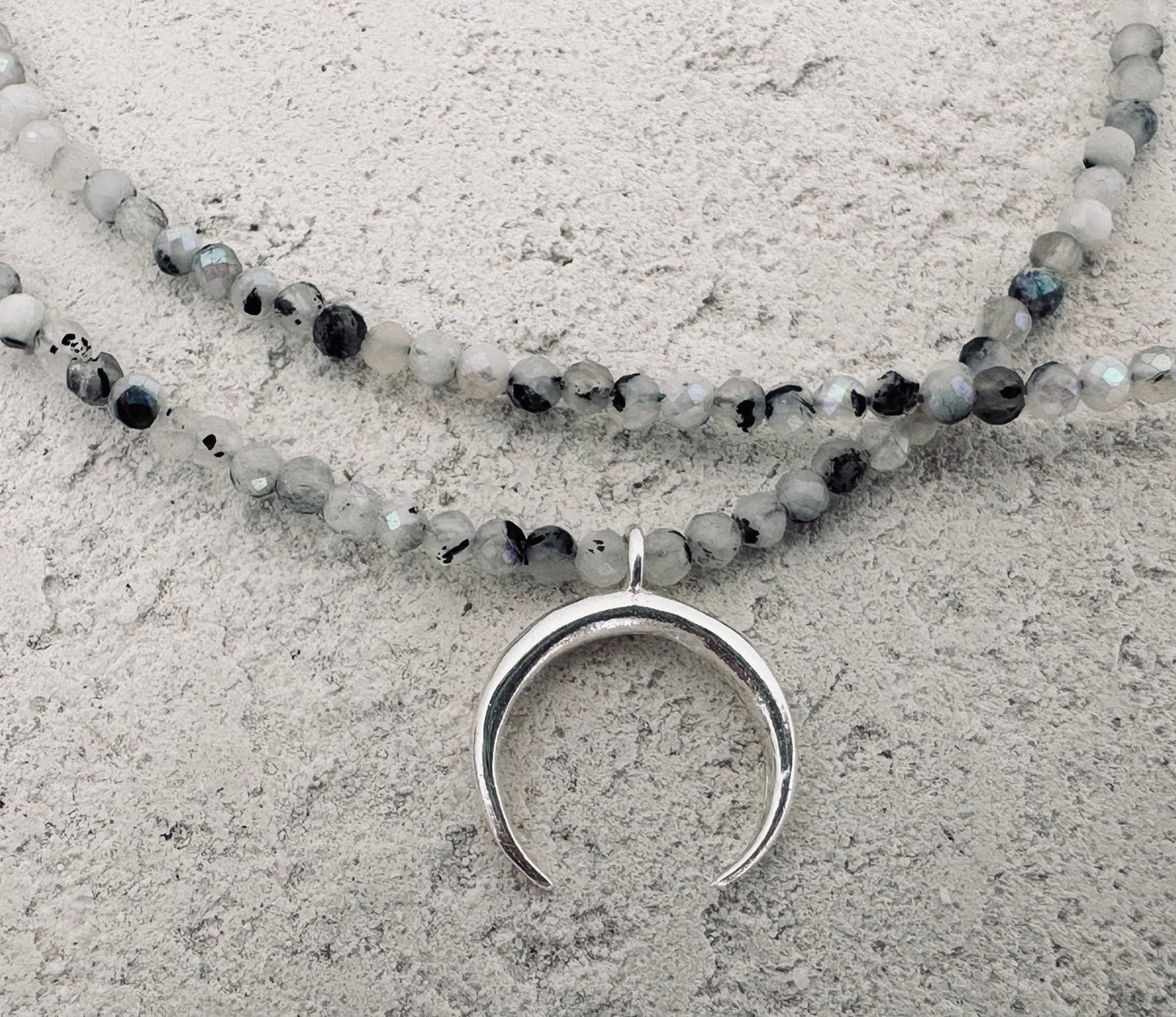 Small light grey stones and silver moon necklace. 