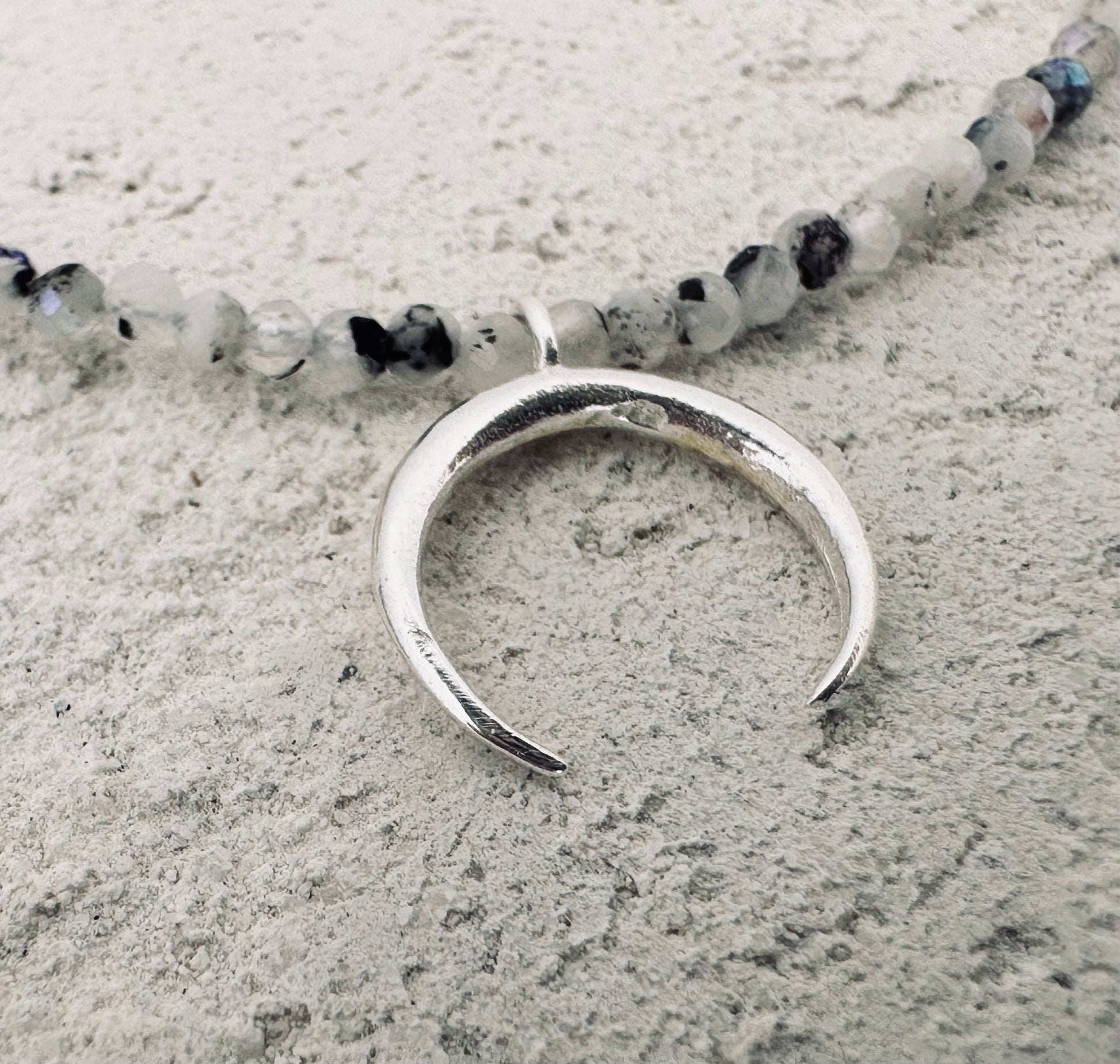 Silver moon necklace with a small stones. 